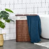 bamboo-laundry-hamper-lid_8 Brown two-compartment hamper with a blue towel draped over the lid