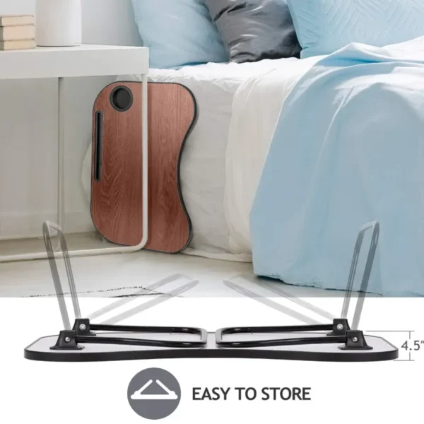 foldable lap desk folded and standing beside a bed with pillows and blankets