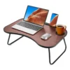 foldable lap desk folded and standing beside a bed with pillows and blankets