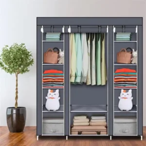 Gray portable closet organizer in a bedroom holding hanging clothes and folded stacks